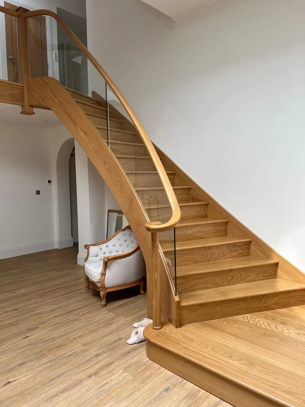 Oak curved closed string staircase, glass balustrade with oak handrail